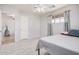 Bedroom with tile floors, ceiling fan, and gray curtains with a glimpse into a carpeted living area at 2750 W Turney Ave, Phoenix, AZ 85017