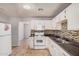 Functional kitchen with white cabinetry, mosaic backsplash, black countertops, and white appliances at 2750 W Turney Ave, Phoenix, AZ 85017