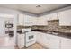 Inviting kitchen features white cabinets, mosaic backsplash, and white appliances for convenient cooking at 2750 W Turney Ave, Phoenix, AZ 85017