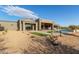 Stunning backyard boasts a pool, covered patio, artificial turf, and beautiful desert landscaping for relaxation at 31226 N Granite Reef Rd, Scottsdale, AZ 85266