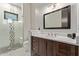 Modern bathroom featuring a glass-enclosed shower with accent tiles, a dark wood vanity, and stone countertops at 31226 N Granite Reef Rd, Scottsdale, AZ 85266