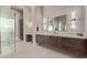 Stylish bathroom with a glass-enclosed shower, dark wood cabinets, white countertops, and modern lighting fixtures at 31226 N Granite Reef Rd, Scottsdale, AZ 85266