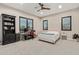 Bright bedroom featuring a ceiling fan, three large windows, a bookshelf, and an adjacent desk at 31226 N Granite Reef Rd, Scottsdale, AZ 85266