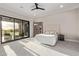 Bright bedroom featuring a tufted headboard, ceiling fan, and large sliding glass doors to outdoor living area at 31226 N Granite Reef Rd, Scottsdale, AZ 85266