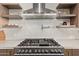 Close-up of stainless steel stove with floating shelves in the bright kitchen at 31226 N Granite Reef Rd, Scottsdale, AZ 85266