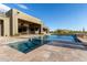 Lush pool area with covered patio, dining set, and pristine pool surrounded by desert flora and fauna at 31226 N Granite Reef Rd, Scottsdale, AZ 85266