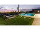 A serene backyard with a sparkling pool and lounge chairs on lush turf, surrounded by cacti at 31226 N Granite Reef Rd, Scottsdale, AZ 85266