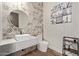 Stylish powder room with patterned accent wall, a contemporary vessel sink, a sleek toilet, and wood flooring at 31226 N Granite Reef Rd, Scottsdale, AZ 85266
