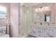 Bright bathroom featuring a dual sink vanity, glass enclosed shower, and decorative wallpaper at 313 W Utopia Rd, Phoenix, AZ 85027