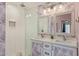 Bright bathroom featuring a dual sink vanity, glass enclosed shower, and decorative wallpaper at 313 W Utopia Rd, Phoenix, AZ 85027