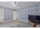 Stylish bedroom with floral wallpaper, ceiling fan, and light wood floors at 313 W Utopia Rd, Phoenix, AZ 85027