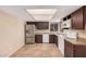 Functional kitchen with stainless steel refrigerator, white appliances, dark cabinetry, and tile flooring, offering ample counter space at 3540 E Dolphin Ave, Mesa, AZ 85204