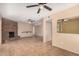 Spacious living room with a brick fireplace, tile flooring, ceiling fans, and large windows providing natural light at 3540 E Dolphin Ave, Mesa, AZ 85204