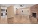 Spacious living room with a cozy brick fireplace, tile flooring, and an open layout with multiple ceiling fans at 3540 E Dolphin Ave, Mesa, AZ 85204