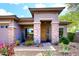 Inviting front porch with stone pillars, lush plants, and a cozy bench, adding charm to the home at 35707 N 34Th Ln, Phoenix, AZ 85086