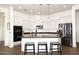 Modern kitchen features white cabinets, stainless steel appliances, dark countertop and island with bar seating at 35707 N 34Th Ln, Phoenix, AZ 85086