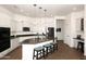 Bright kitchen features white cabinets and island with bar seating, stainless steel appliances, and stone countertops at 35707 N 34Th Ln, Phoenix, AZ 85086