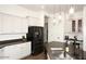 Well-lit kitchen with stone countertops, white cabinets, stainless steel appliances, and a sink with a modern faucet at 35707 N 34Th Ln, Phoenix, AZ 85086
