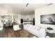 Open floor plan with living room flowing into the kitchen and dining area, hardwood floors, and neutral decor at 35707 N 34Th Ln, Phoenix, AZ 85086