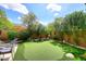 Lush putting green bordered by a block fence, bushes and desert landscaping at 35707 N 34Th Ln, Phoenix, AZ 85086