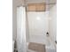 Clean shower with a white shower curtain, grab bar, and window for added natural light at 35707 N 34Th Ln, Phoenix, AZ 85086