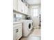 Well-lit laundry room with modern washer and dryer, ample storage, and white cabinetry at 3879 E Harrison St, Gilbert, AZ 85295