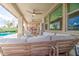 Relaxing covered patio with comfortable seating, ceiling fans, and an outdoor dining area overlooking the pool at 3879 E Harrison St, Gilbert, AZ 85295