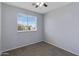 Bedroom with ceiling fan, carpet, and large window with backyard view at 43860 W Roth Rd, Maricopa, AZ 85138
