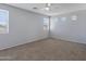 Large bedroom with carpet, three bright windows, and ceiling fan at 43860 W Roth Rd, Maricopa, AZ 85138