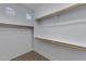 Walk-in closet with built-in shelves and rods for organized storage solutions at 43860 W Roth Rd, Maricopa, AZ 85138