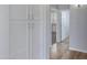 Hallway featuring white cabinets, wood floors, and access to rooms at 43860 W Roth Rd, Maricopa, AZ 85138
