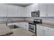 Modern kitchen featuring granite countertops, stainless steel appliances, and sleek white cabinets at 43860 W Roth Rd, Maricopa, AZ 85138