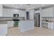 Well-lit kitchen features white cabinets, granite counters, stainless steel appliances, and a breakfast bar at 43860 W Roth Rd, Maricopa, AZ 85138