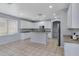 Bright kitchen with white cabinets, stainless steel appliances, and a large island with breakfast bar at 43860 W Roth Rd, Maricopa, AZ 85138