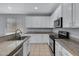Close-up of the kitchen featuring granite countertops, stainless steel appliances, and white cabinets at 43860 W Roth Rd, Maricopa, AZ 85138