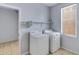 Bright laundry room features modern appliances, shelving, and tiled floors at 43860 W Roth Rd, Maricopa, AZ 85138