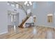 Spacious living room with hardwood floors, high ceilings, staircase, and ample natural light, perfect for entertaining at 43860 W Roth Rd, Maricopa, AZ 85138