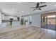Bright living room with wood floors, open to the kitchen, and a sliding door to the patio at 43860 W Roth Rd, Maricopa, AZ 85138
