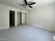 Bright bedroom with plush carpeting, a ceiling fan, and closet with mirrored doors at 4444 E Paradise Village N Pkwy # 251, Phoenix, AZ 85032