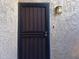 Apartment front door with a black metal security gate and stucco siding at 4444 E Paradise Village N Pkwy # 251, Phoenix, AZ 85032