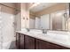 A bathroom with a double sink vanity, dark cabinets, and a shower-tub combination at 4752 E Portola Valley Dr # 103, Gilbert, AZ 85297