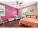 A bedroom features a dark accent wall, wood floors, plus a bed and crib at 4752 E Portola Valley Dr # 103, Gilbert, AZ 85297
