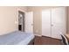 Bright bedroom featuring wood floors, closet, and a private entry to an ensuite bathroom at 4752 E Portola Valley Dr # 103, Gilbert, AZ 85297