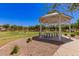 A cozy gazebo with picnic tables sits in a well maintained park with trees at 4752 E Portola Valley Dr # 103, Gilbert, AZ 85297