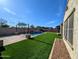 Expansive backyard with artificial grass, refreshing swimming pool, and ample patio space at 5304 S Wesley S Cir, Mesa, AZ 85212