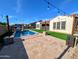 Beautiful backyard featuring a pool, tile patio, synthetic grass, and cozy string lights under a clear sky at 5304 S Wesley S Cir, Mesa, AZ 85212