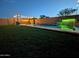 A beautiful backyard pool with waterfalls, lighting, and green grass at 5304 S Wesley S Cir, Mesa, AZ 85212