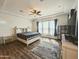 Spacious main bedroom with wood floors, tray ceilings, fan, and many windows with natural light at 5304 S Wesley S Cir, Mesa, AZ 85212