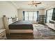 Bright main bedroom featuring wood floors, a ceiling fan, and a large window with neutral colors at 5304 S Wesley S Cir, Mesa, AZ 85212