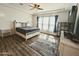 Light filled main bedroom with a ceiling fan, dark wood floors, and plantation shutters at 5304 S Wesley S Cir, Mesa, AZ 85212